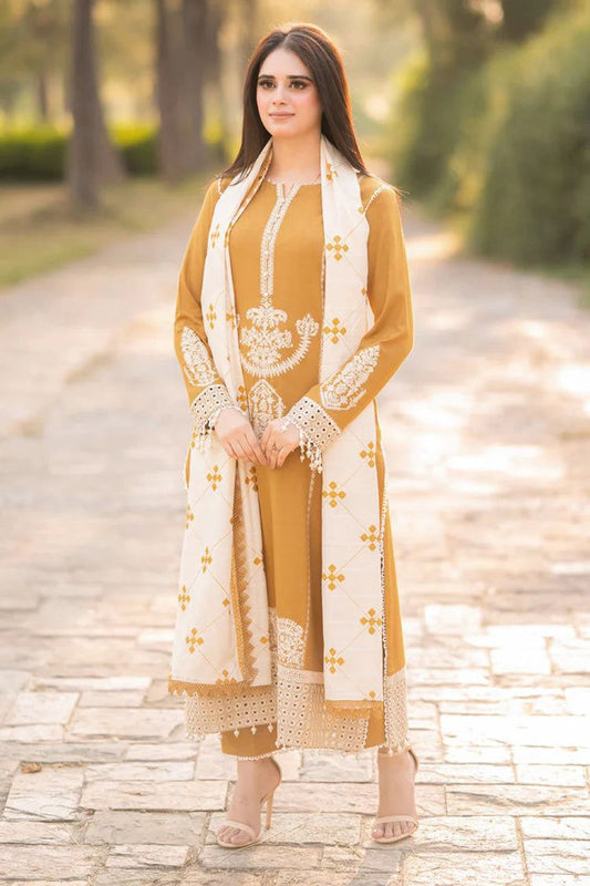 A woman wearing a mustard yellow and white embroidered traditional outfit standing outdoors on a paved path.